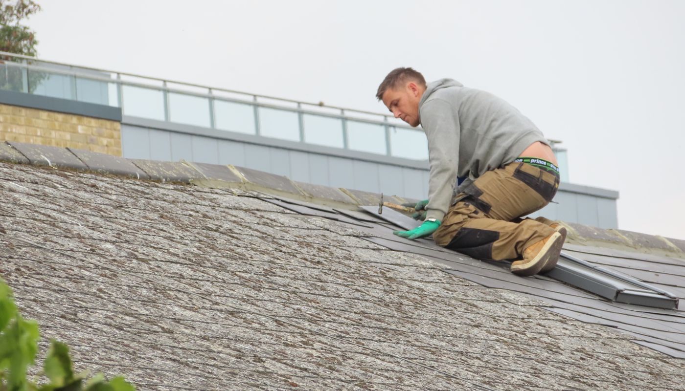 Artisan installant une toiture, vue rapprochée du travail de couverture